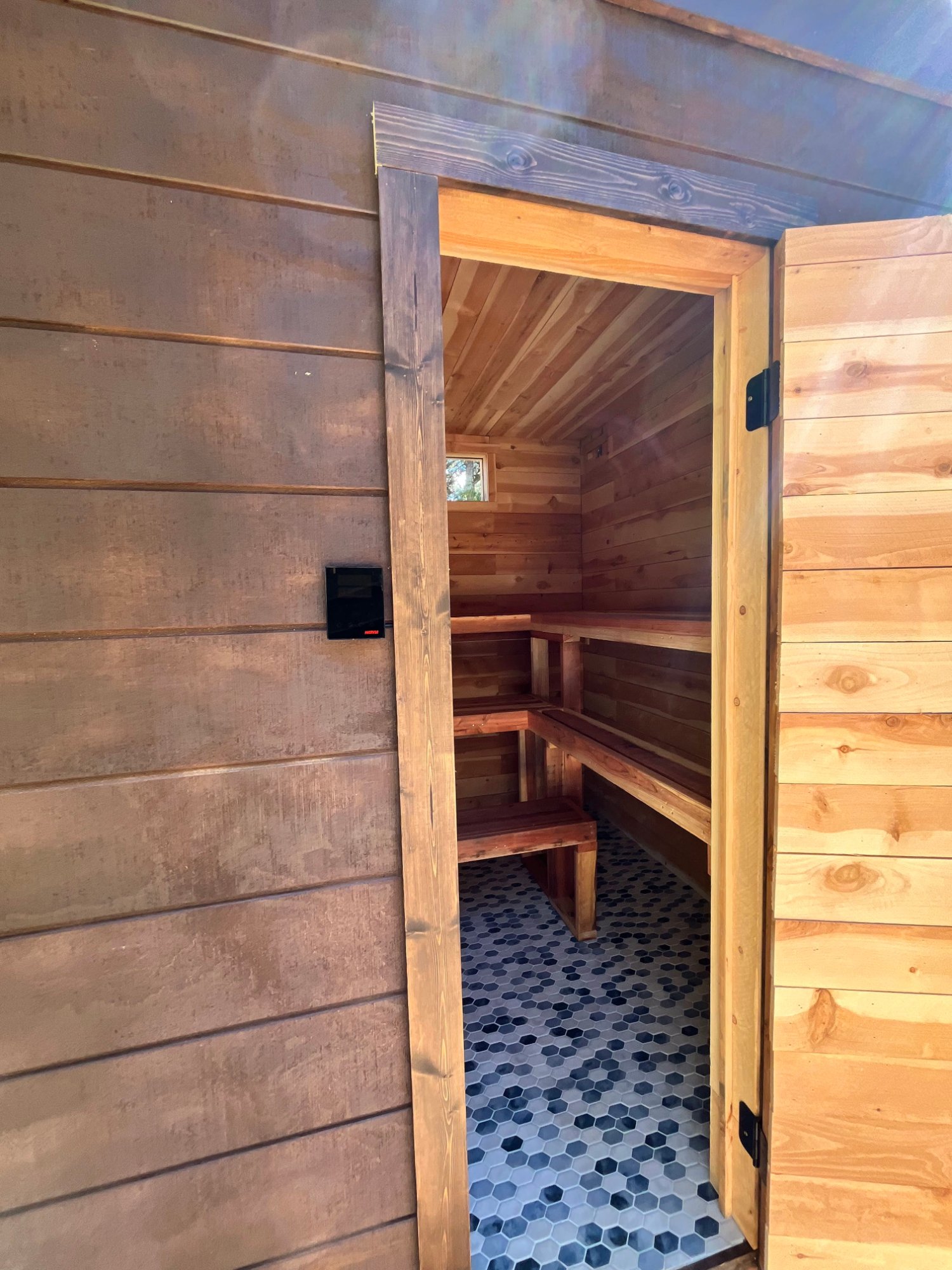 8x8 privacy-first sauna with a Harvia Cilindro and tiled wet-room floor